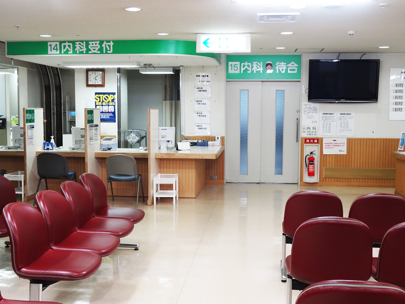 内科受付はついたてが立てられていて個別で受け付けることができます。周りはいすが並べられていてテレビが配置されています